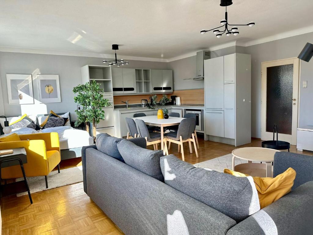 un soggiorno con divano blu e una cucina di Prater Apartment - Loggia a Vienna