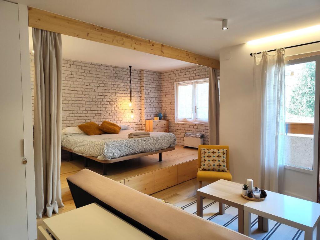 1 dormitorio con cama y pared de ladrillo en Apartamento Marcos, en Villanúa