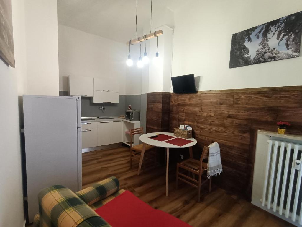 a living room with a table and a kitchen at MountainAosta - CIR 0062 in Aosta