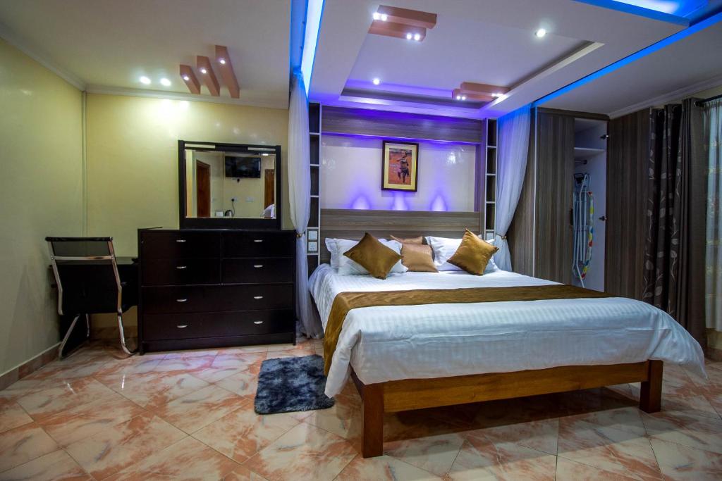 a bedroom with a large bed and a mirror at opal oasis in Kahawa