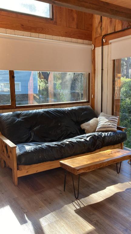 a black leather couch in a room with a window at A Modo Mío in San Carlos de Bariloche