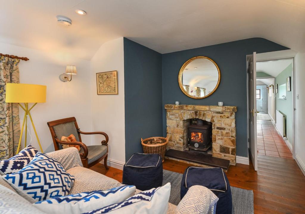 a living room with a fireplace and a mirror at Trefaes Bach in Abersoch