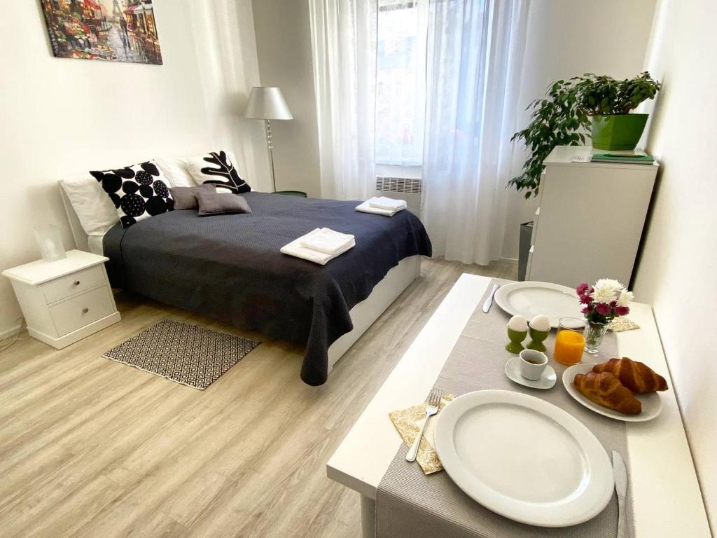 布拉格的住宿－Homelike Prague Apartment，一间卧室配有一张床和一张桌子,上面有食物