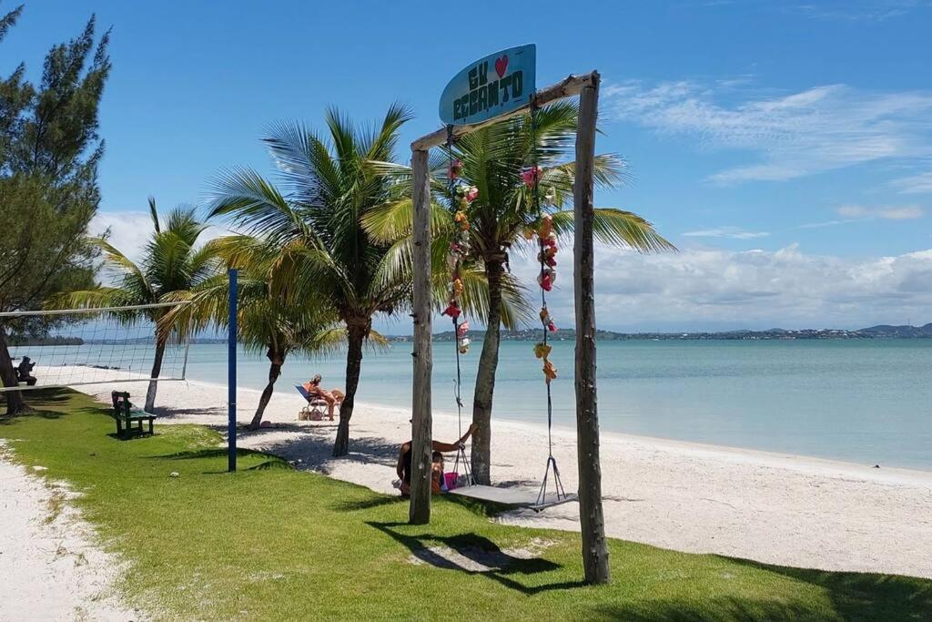 una playa con palmeras y un cartel en ella en Morada do sol, en Arraial do Cabo