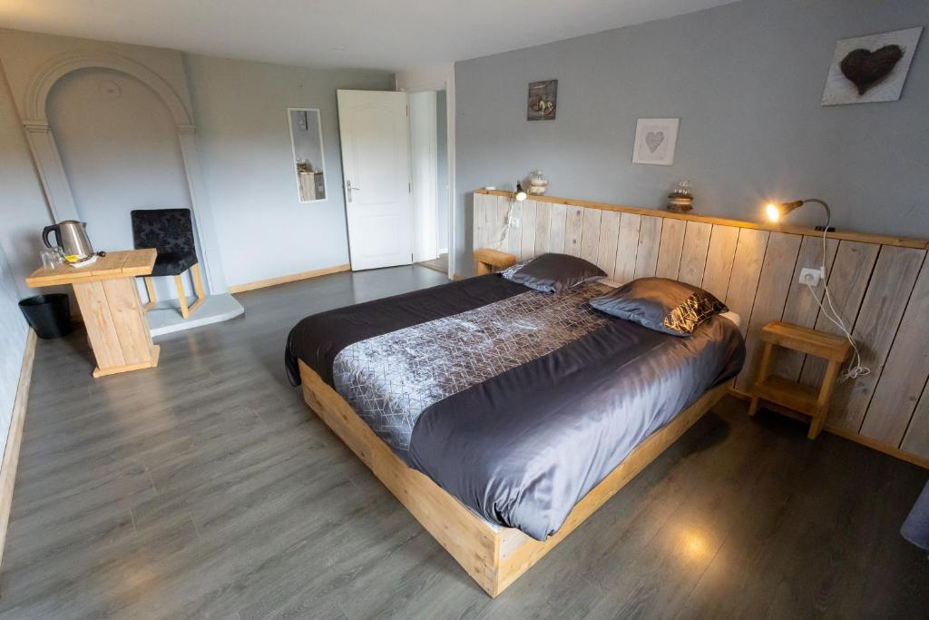 CHAMBRE D'HOTE في Granges-sur-Vologne: غرفة نوم بسرير خشبي في غرفة