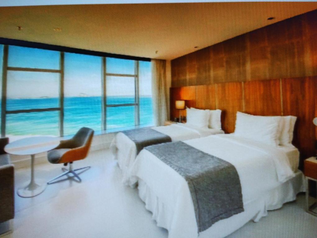 two beds in a hotel room with a view of the ocean at Hotel Nacional in Rio de Janeiro