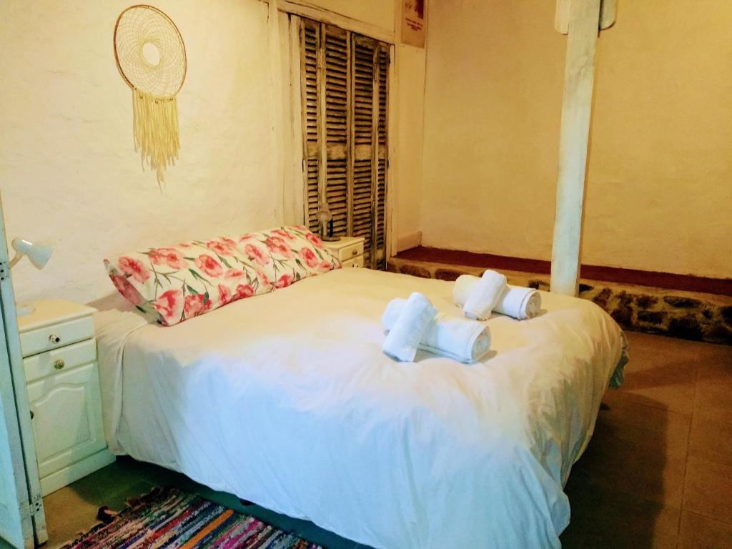 a bedroom with a bed with towels on it at Casitas del Cerro in Chacras de Coria