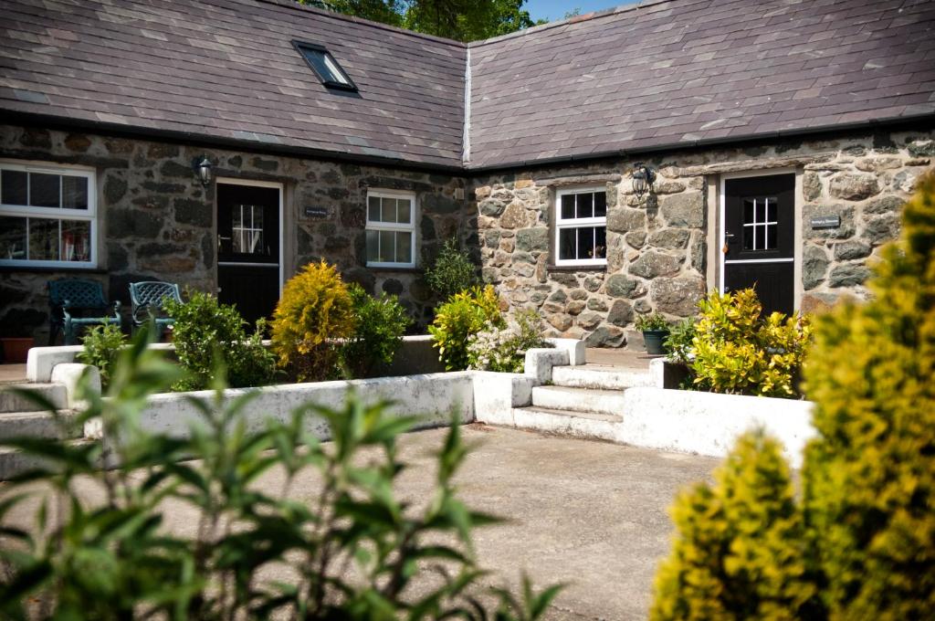an old stone house with a garden in front of it at RB Contractor Stays - Dderwen in Pwllheli