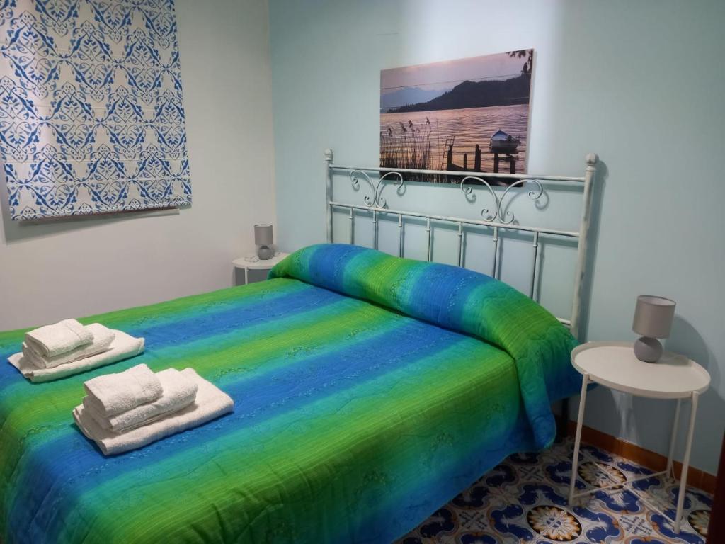 - une chambre avec un lit et des serviettes dans l'établissement casa vacanze Sicilia Bedda Seaside, à Santa Flavia