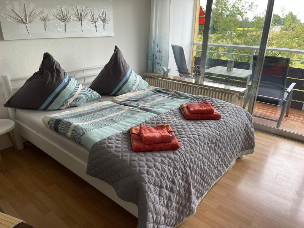 Una cama con dos almohadas rojas encima. en Apartment-Thermen-Zeit, en Bad Füssing