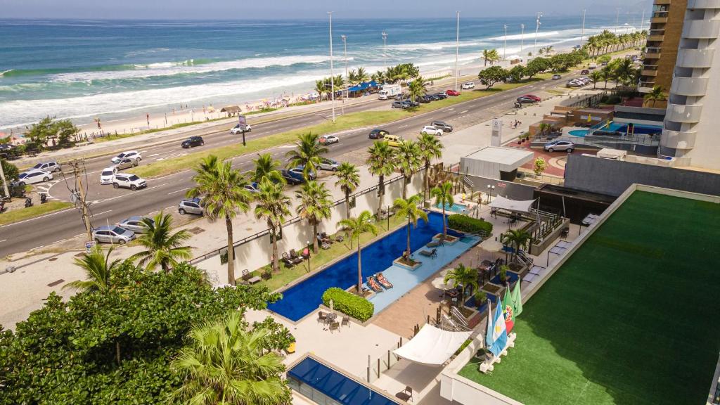 an aerial view of a beach with palm trees and a building at Laghetto Stilo Barra in Rio de Janeiro