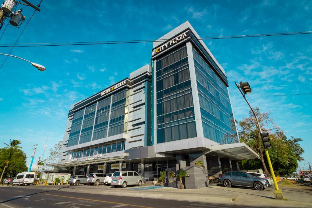 a building with cars parked in front of it at Hotel City Plaza & Suites in David