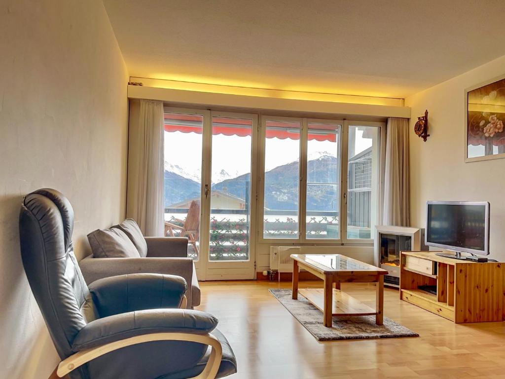 a living room with a couch and a table and a television at Appartement l Magnifique vue l Proche Crans-Montana in Crans-Montana
