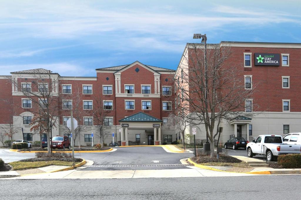 a large red brick building with a parking lot at Extended Stay America Suites - Washington, DC - Fairfax - Fair Oaks Mall in Fairfax