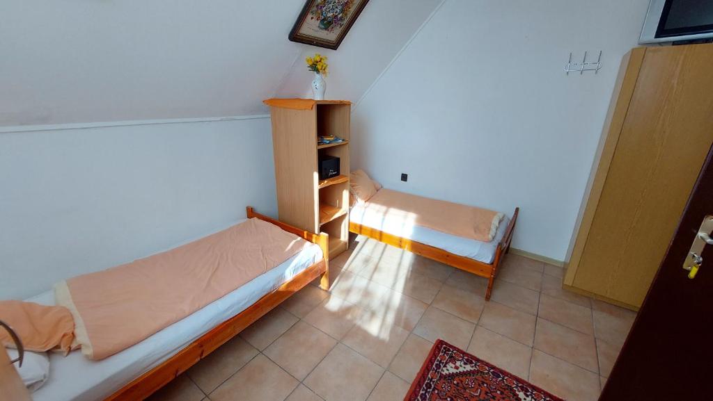a small room with two beds in a room at Pihenés a Malomtónál privát bérlemény in Tapolca