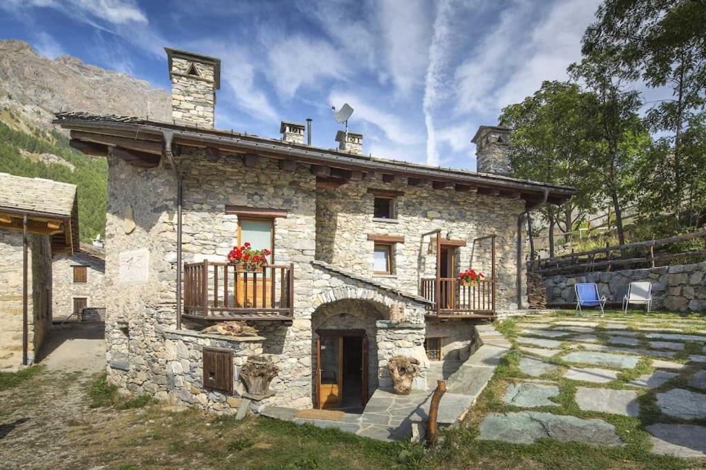 a stone house with a balcony on the side of it at La Mizoùn de Marguerito - Appartamento Ginestra in Acceglio