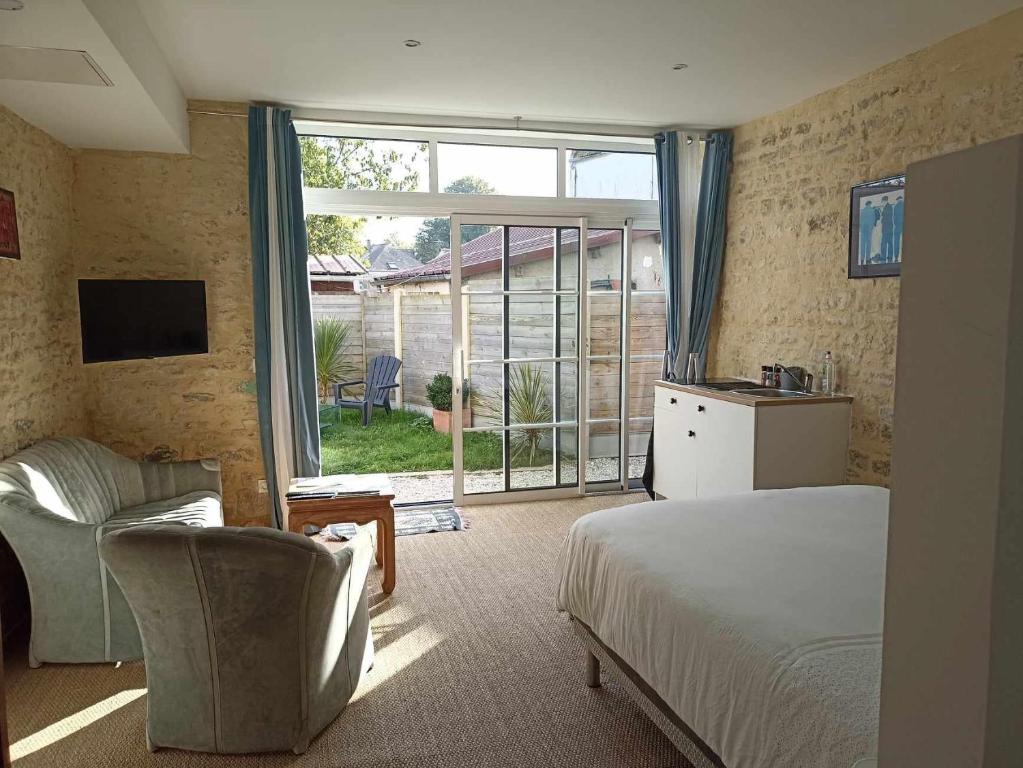 a bedroom with a bed and a sliding glass door at Villa kahlo Omaha Beach in Colleville-sur-Mer