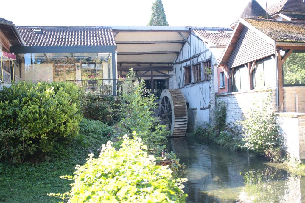 a house with a stream in front of it at Le Moulin Du Landion Hôtel et Spa in Dolancourt