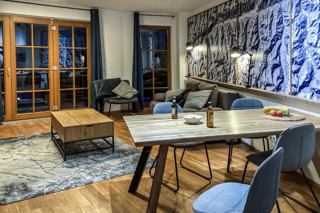 Andrea 7 by SMR Rauris Apartments - inc Spa and National Summercard - near Gondola في راوريس: غرفة معيشة مع طاولة وكراسي