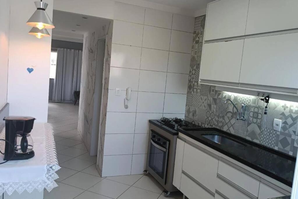 een keuken met een wastafel en een fornuis top oven bij Apartamento a 1200m da praia 2 quartos in Vila Velha