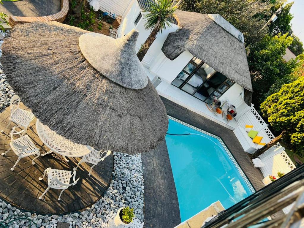 an overhead view of a swimming pool with a umbrella and chairs at Sbukosezwe guest house in Johannesburg