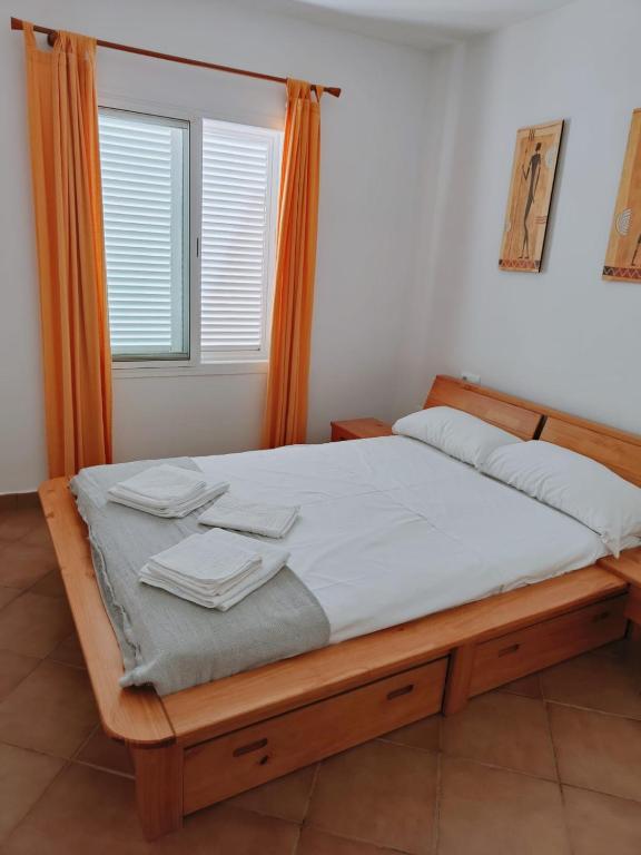 a bedroom with a wooden bed with towels on it at Pita 1 in Níjar