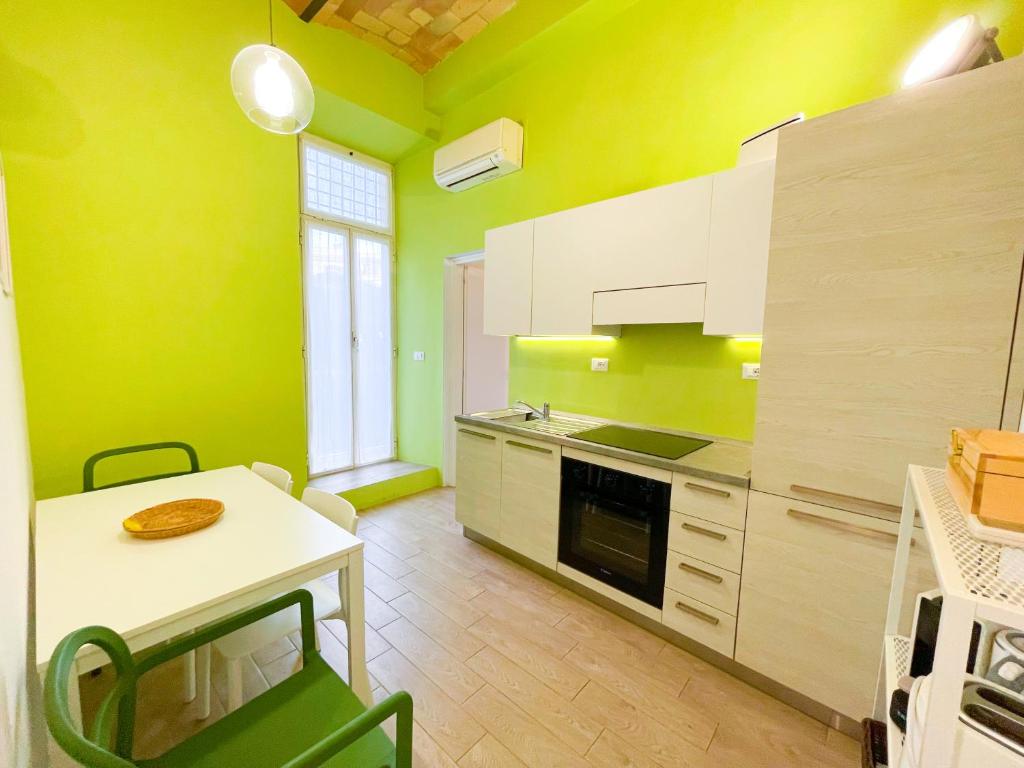 a kitchen with green walls and a table and a counter at Casa Pesa 2 rooms 2 baths Rome center in Rome