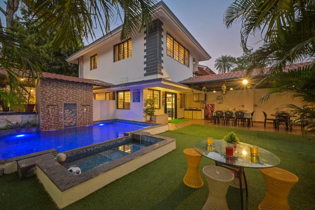 a backyard with a swimming pool and a house at Great Escape Villa by Tropicana Stays in Lonavala