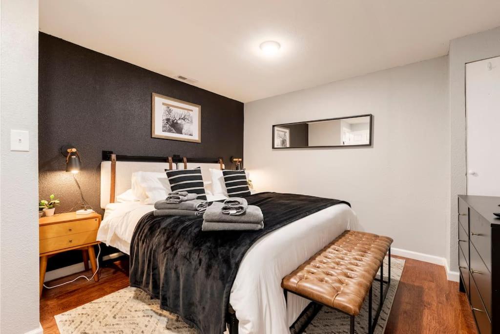 - une chambre avec un grand lit et un mur noir dans l'établissement Adorable 2-Bedroom Modern Basement, à Denver