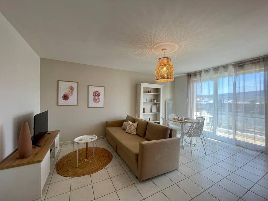 a living room with a couch and a table at CHEZ JOYCE Appartement cocooning in Lons-le-Saunier