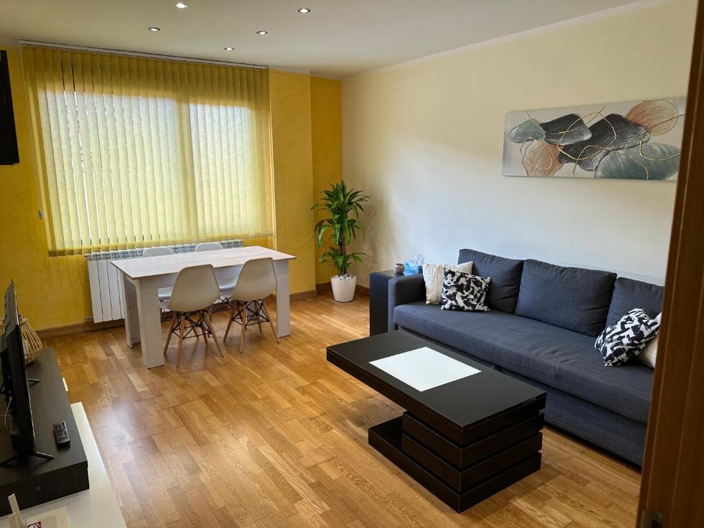 a living room with a blue couch and a table at Piso nuevo totalmente equipado in Toro