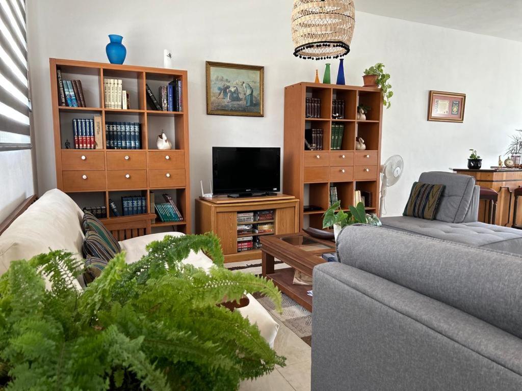 uma sala de estar com um sofá e uma televisão em Casa Cuxtal Tus mejores momentos em Juriquilla