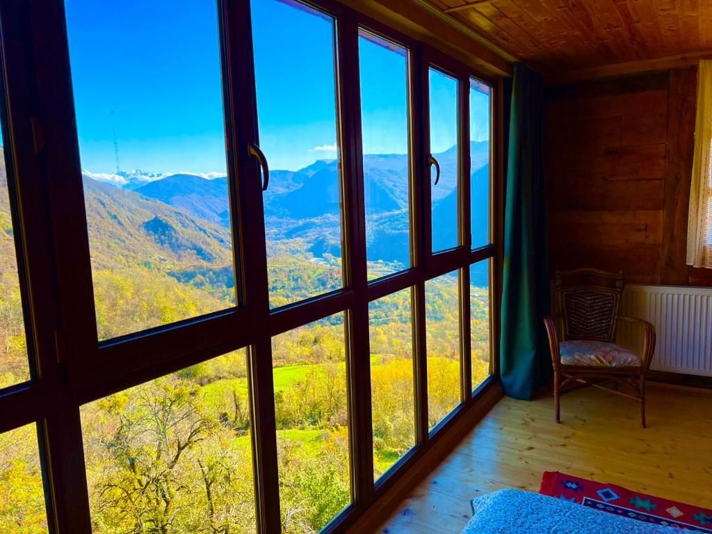 a room with a view of the mountains through windows at Gentry House in Ambrolauri