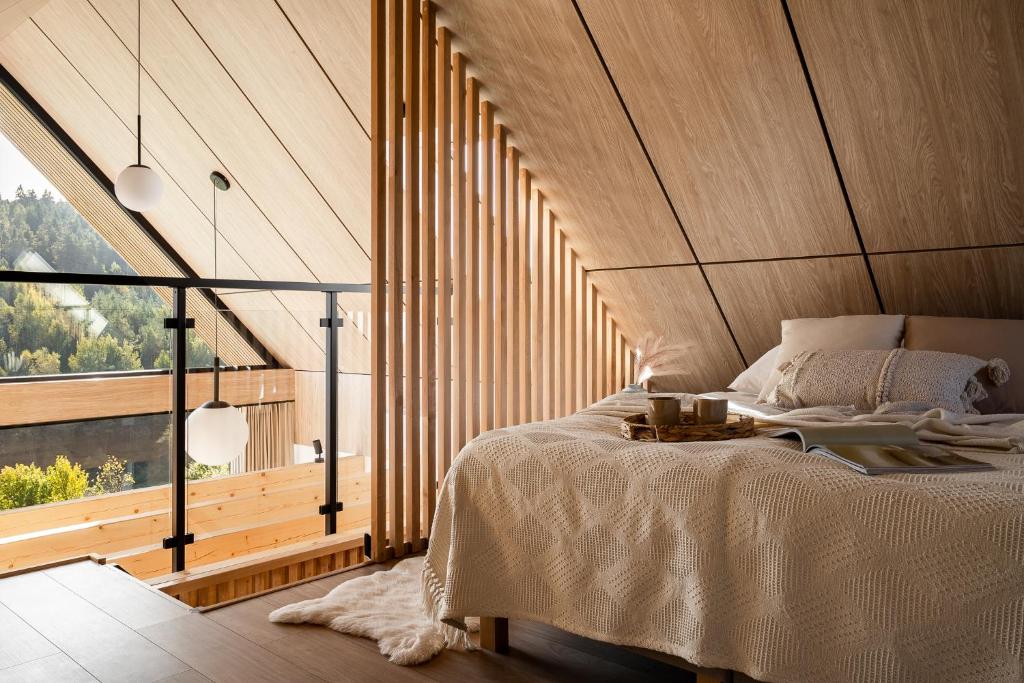 a bedroom with a large bed with a wooden ceiling at NALAS domki z widokiem in Rabka
