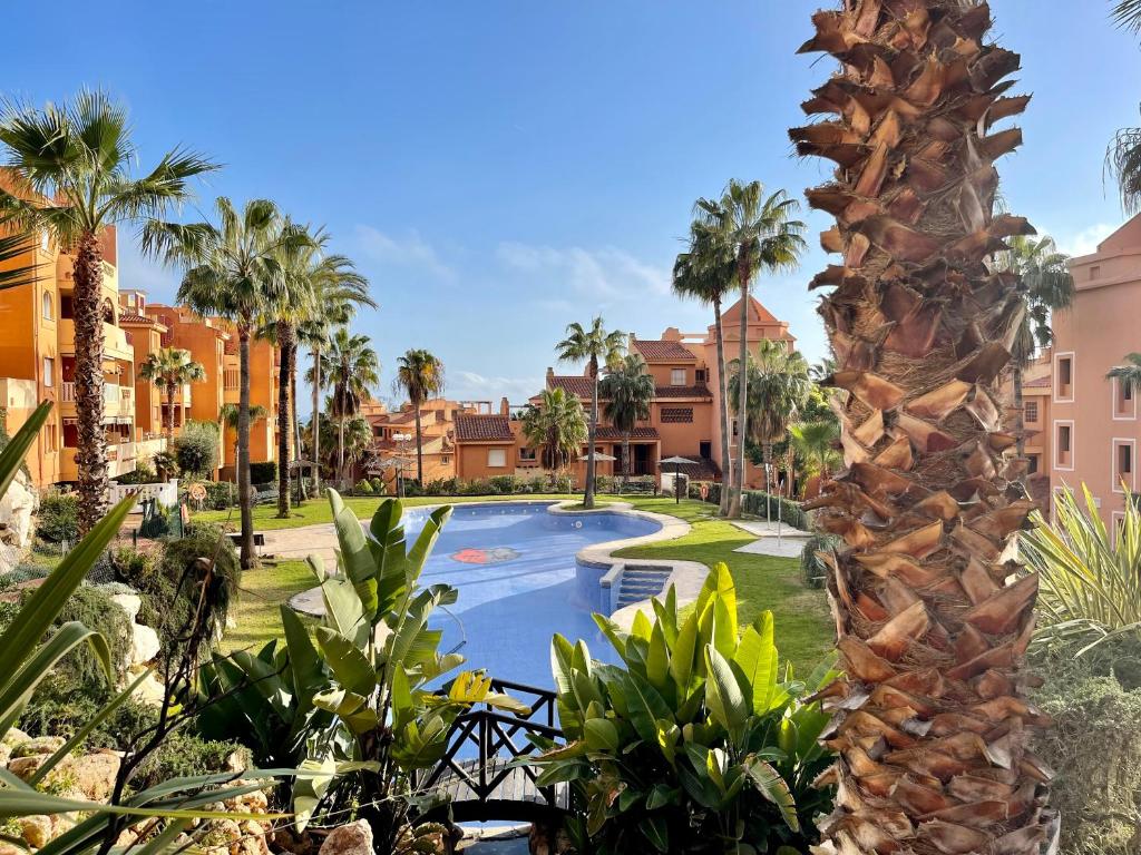 - Vistas a la piscina de un complejo con palmeras en Apartamento con vistas al mar en Reserva de Marbella, en Marbella