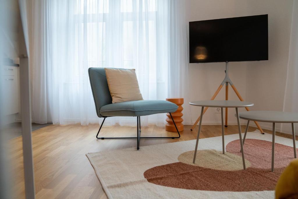 Il comprend un salon avec une chaise et une télévision à écran plat. dans l'établissement theCorner 2-Bedroom Apartment, à Schwändi