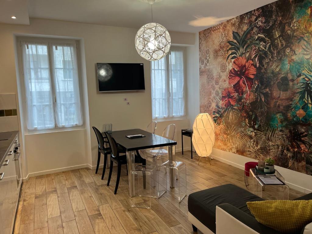 uma sala de estar com uma mesa e uma televisão em Suite & Lake - Proche du Lac d'Annecy em Annecy