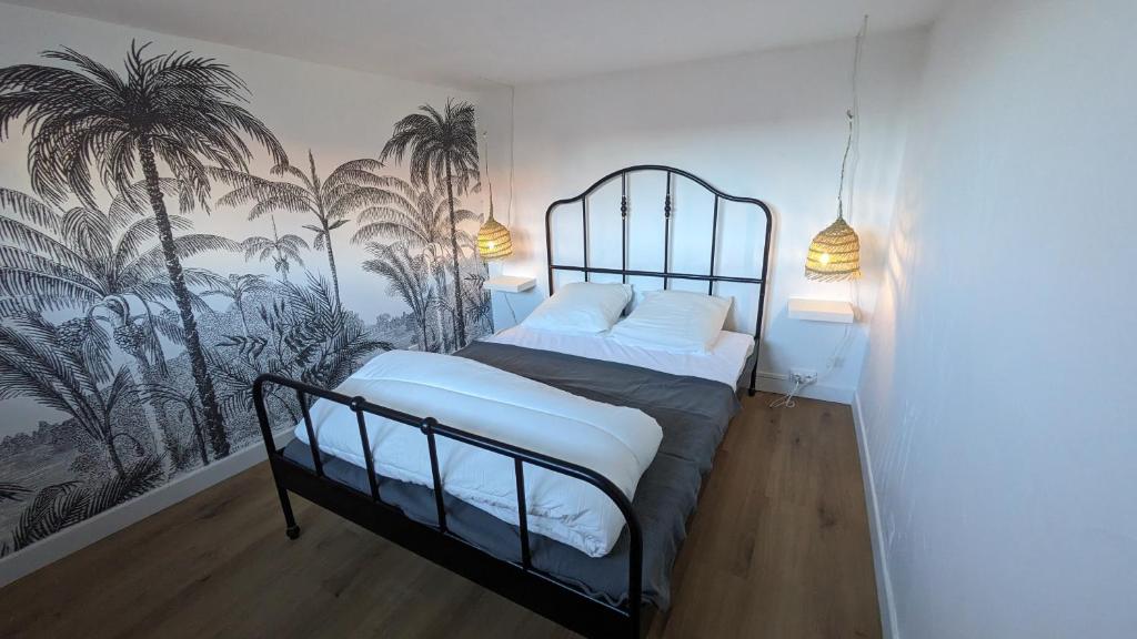 um quarto com uma cama com palmeiras na parede em Casa Menton em Menton