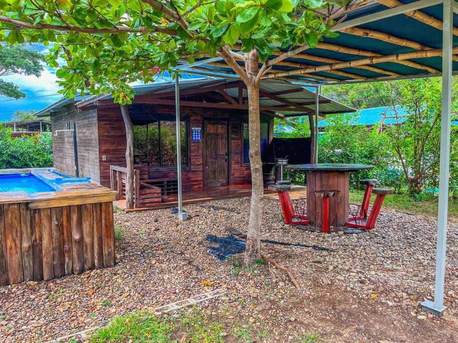 a wooden cabin with a table and a tree at Cabaña D&E en Copal KiteBeach in Playa Copel