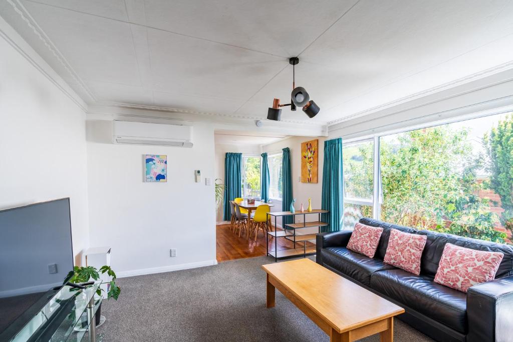 a living room with a couch and a table at Modern home in Dunedin in Dunedin