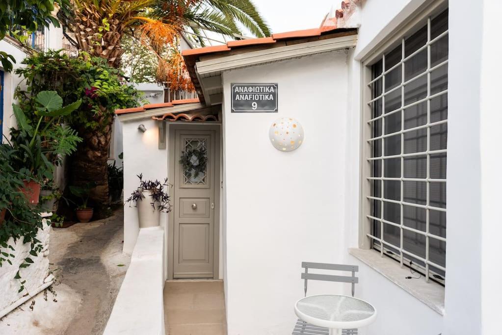 een wit huis met een deur en een bord erop bij Villa Artemis Cycladic Charmed ! in Athene