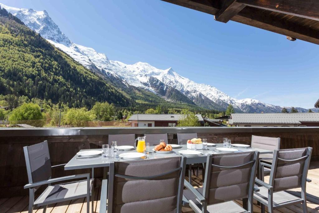 d'une table sur un balcon avec vue sur les montagnes. dans l'établissement Grand Paradis- Modern 3 bedroom apartment with spectacular views, à Chamonix-Mont-Blanc
