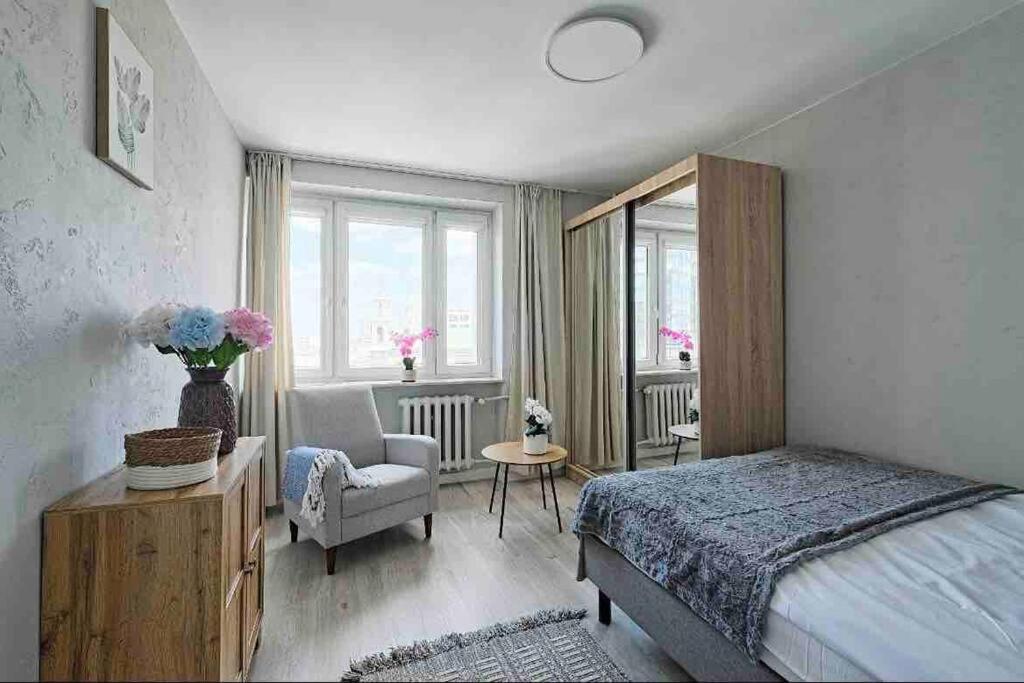 een slaapkamer met een bed, een stoel en een raam bij Emilii Plater 55 Center 2 bedrooms Living room balcony in Warschau
