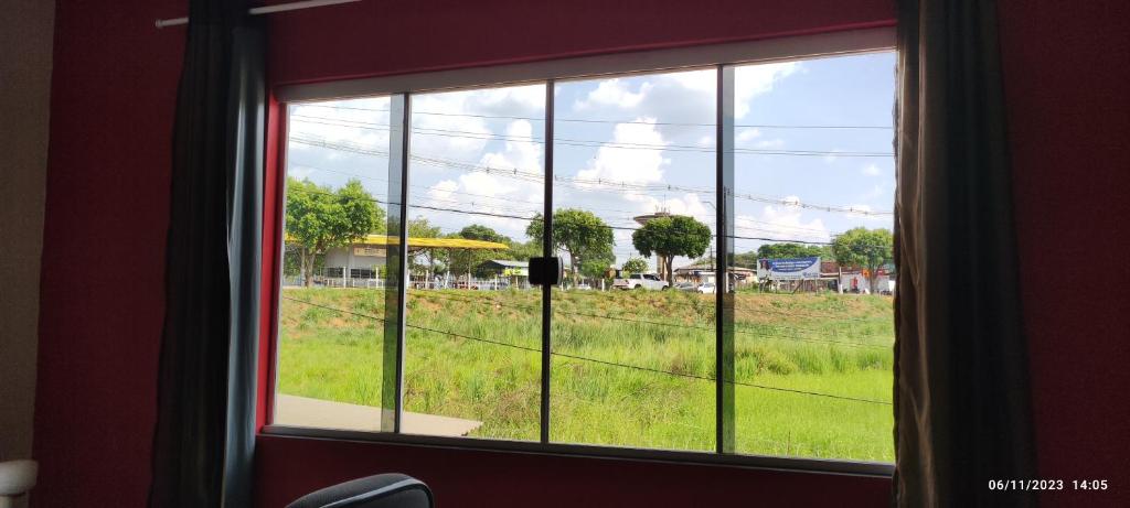 una ventana con vistas a un campo de césped en Hostel Acre, en Rio Branco
