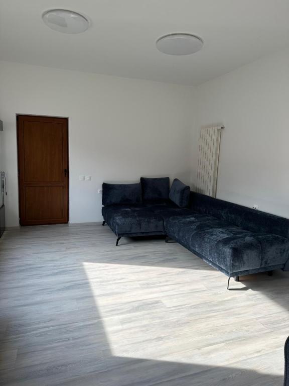 a living room with a black couch in a room at Airport Confort House in Otopeni