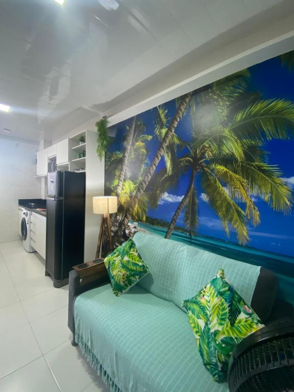 a living room with a blue couch with a palm tree mural at Flat completo no centro de Belém in Belém