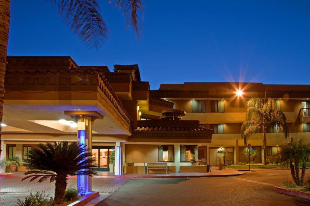 un gran edificio con palmeras delante en Hotel Xola, en Moreno Valley