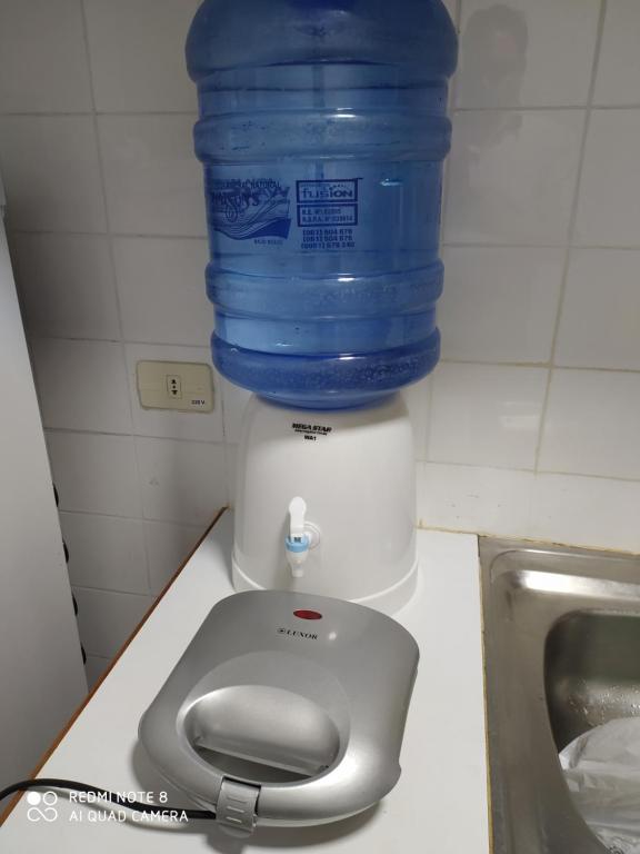 butelka wody znajduje się na górze dozownika wody w obiekcie Moderno y amplio apartamento con vista fantástica en pleno centro w mieście Ciudad del Este