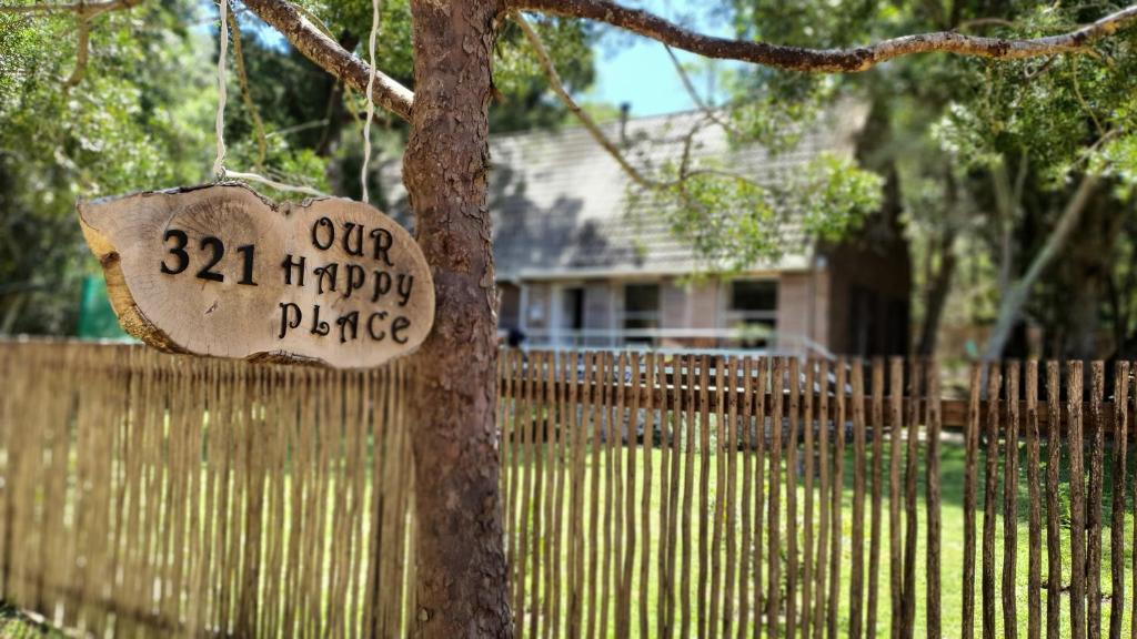 un panneau sur un arbre devant une clôture dans l'établissement Our Happy Place, à Natureʼs Valley