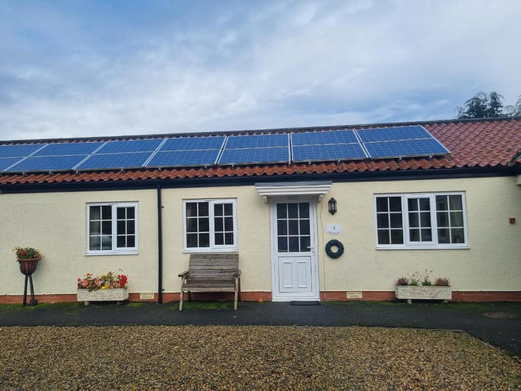 une maison avec des panneaux solaires sur le toit dans l'établissement Richmond Cottage, à Malton